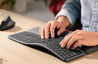 Pessoa mexendo em um teclado ergonomico grande com as duas mãos.