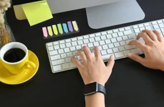foto de homem usando teclado branco sobre uma mesa