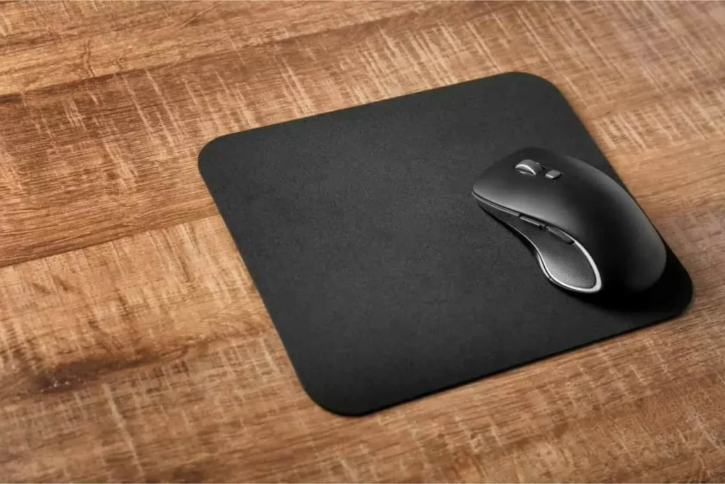 Um mouse preto em cima de um mouse pad preto.